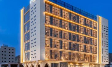 Modern hotel building illuminated at twilight with clear skies, welcoming December 2024 Umrah pilgrims.